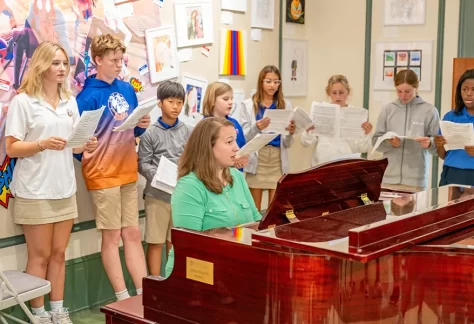 bolles Studentssingingaroundchorusteacheronpiano